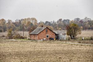 Polskie gospodarstwo rolne jesienią, pola po zbiorach, zabudowania gospodarcze